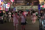 Two young Asian woman walking along a busy street.