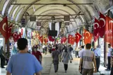 People walking in a market with Turkish flags on each side