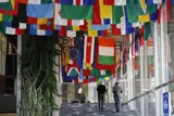 People walk down corridor with flags hanging from ceiling